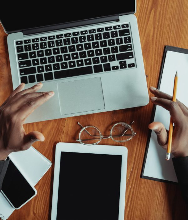Businessman or student working from home being isolated or keep quarantine, coronavirus COVID-19. African-american man using laptop, tablet and headphones. Online conference, lesson, remote office.